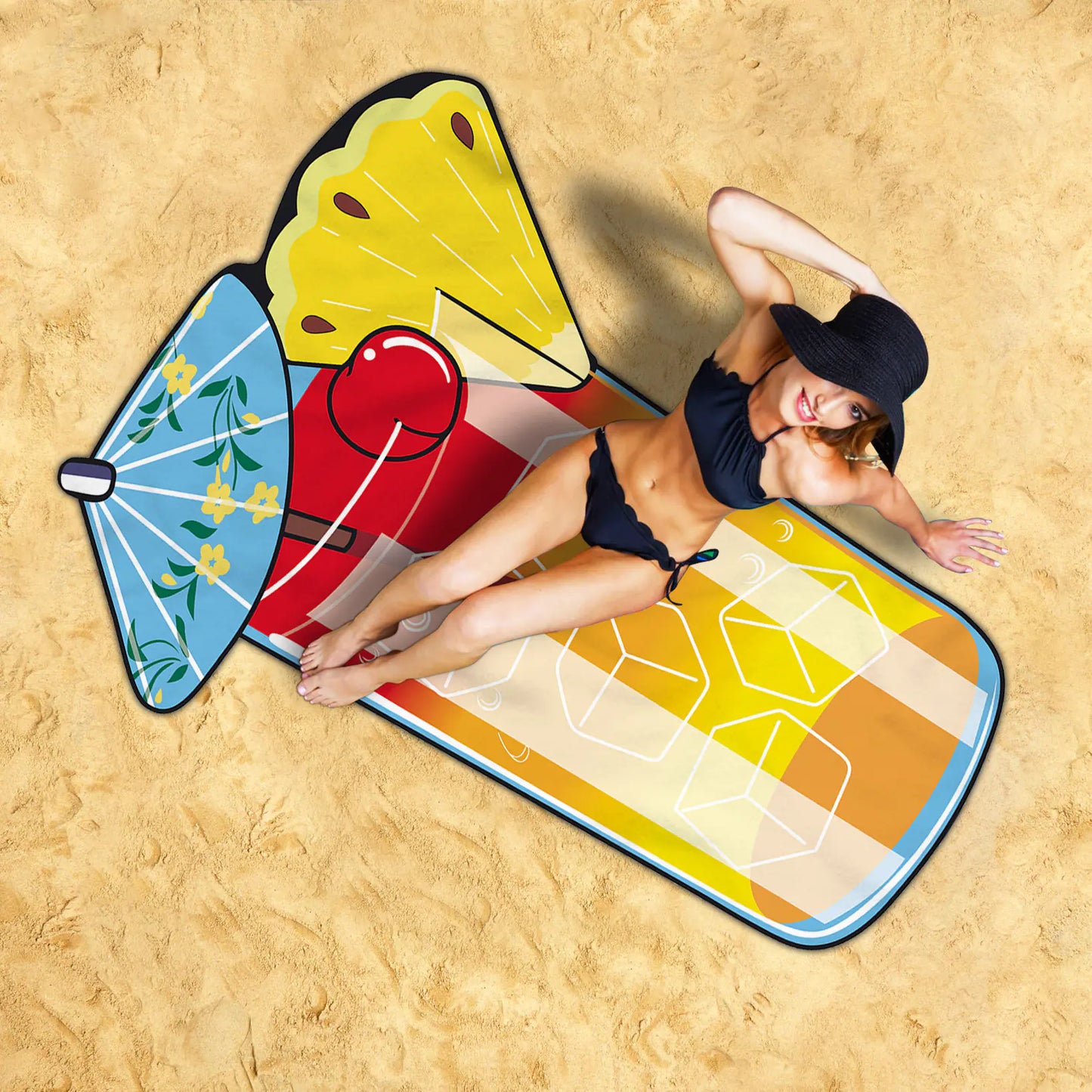 Woman lying on a colourful cocktail beach mat with a hat.