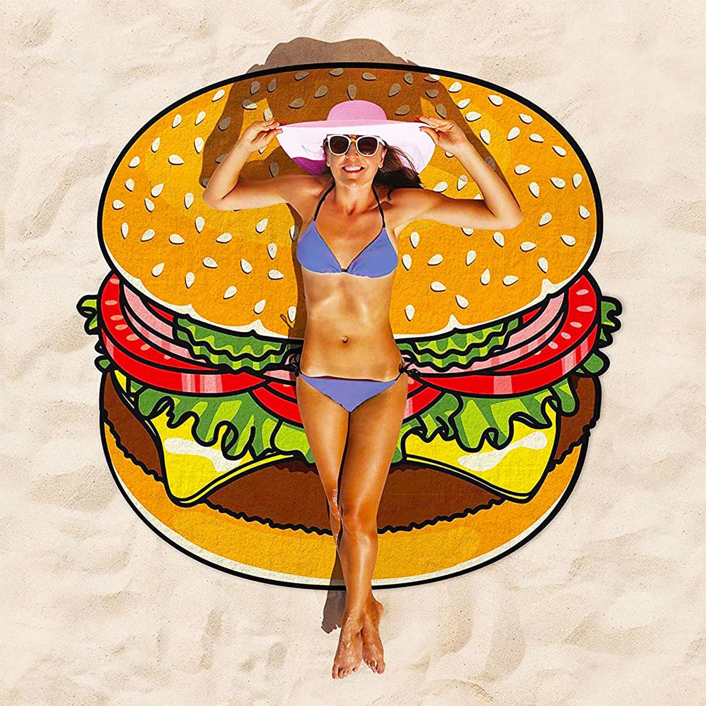 Woman in a bikini standing on a hamburger-shaped towel on sand