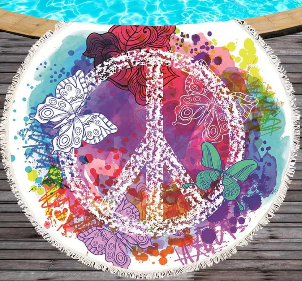 Colorful round towel with peace symbol and butterflies on a wooden deck.