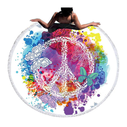 Colorful round towel with peace symbol and butterflies, person lying on it.