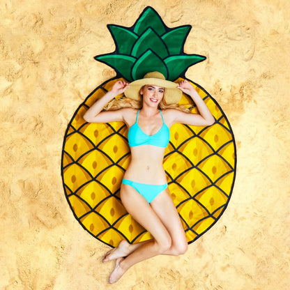 Woman lying on a pineapple-shaped beach towel on sand